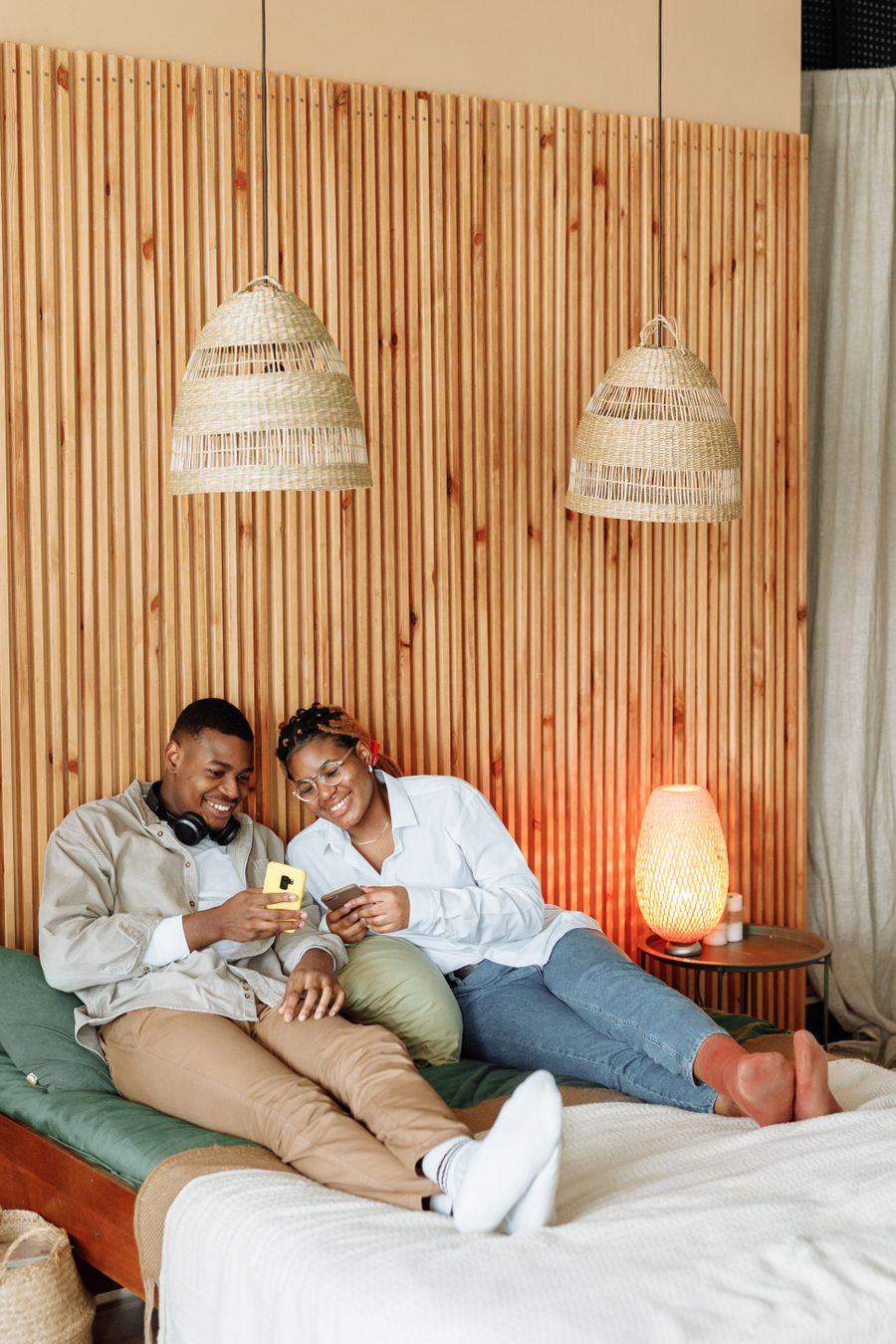 A couple smiling together over their phone at home